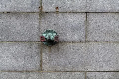 Fire hydrant water pipe, mounted in a building wall. Manhattan USA Stock Photos