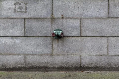 Fire hydrant water pipe, mounted in a building wall. Manhattan USA Stock Photos