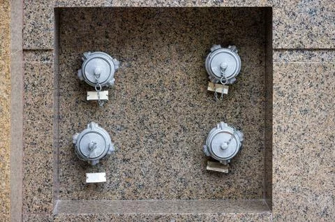 Fire hydrants embedded in the granite wall of the building. Foto stock