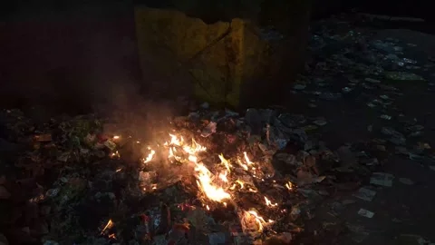 Fire ignites in urban area as trash burns amidst towering stacks of waste a.. Stock Footage 311225820