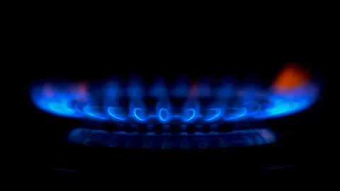 Fire igniting on a gas stove. From a state of complete darkness, blue flame of Stock Footage 99281113