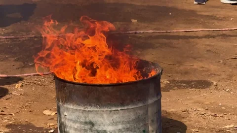 Fire igniting inside rusty drum for firefighting training exercise. Stock Footage 342041284