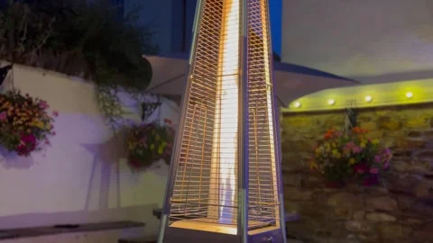 Fire lantern in back corner of pub garden infront of hanging baskets on wall Stock Footage 247019649