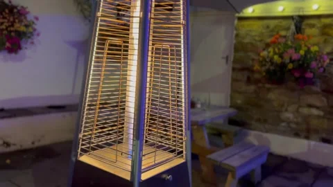 Fire lantern at night in quiet pub garden infront of plant covered wall Stock Footage 247019662