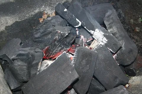 Fire on logs in fire pot with embers and burning coal and blazing flames. Stock Photos