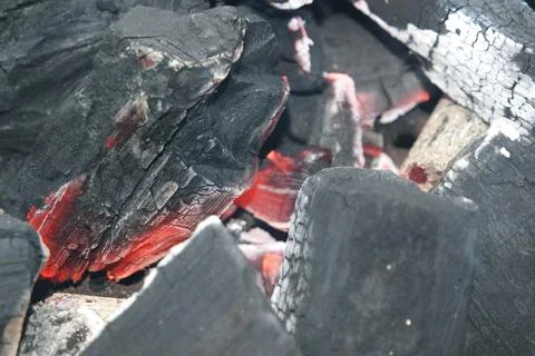Fire on logs in fire pot with embers and burning coal and blazing flames. Stock Photos