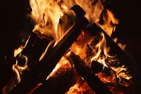 Fire - orange fire flames in the fireplace, burning wooden logs at night Stock Photos
