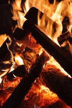 Fire - orange fire flames in the fireplace, burning wooden logs at night Stock Photos