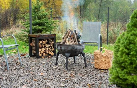 Fire pit and burning fire in a garden Stock Photos