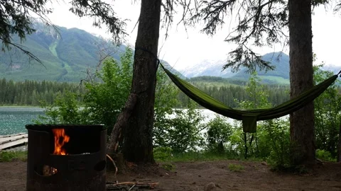Fire Pit in a Campground with a Hammock on the Trees and Views of the Lake Stock Footage 279672044