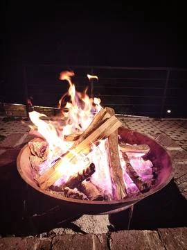 Fire Pit Flames Lighting Up Stone Paving in the Darkness Stock Photos