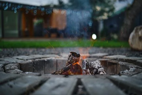 Fire pit glowing with warmth in a cozy outdoor setting during twilight hours Stock-Fotos