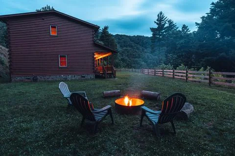 Fire pit. Outdoor fire pit with red flame. Cozy Log cabin home in Mountain Stock Photos