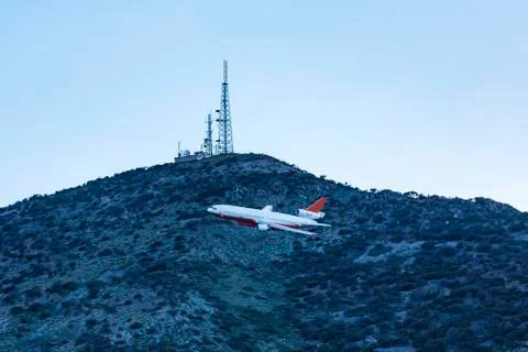 Fire plane flies close to communications tower low to the ground trying to re Stock Photos