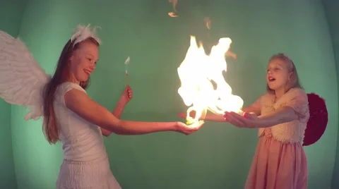 Fire. playing with fire. Two beautiful girls dressed as an angel, Video stock 59661344