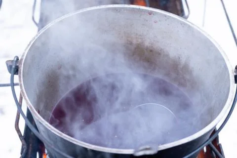 On a fire in a pot preparing mulled wine. Hot red wine on an open fire in win Stock Photos