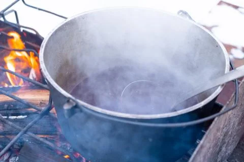 On a fire in a pot preparing mulled wine. Hot red wine on an open fire in win Foto stock