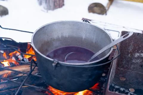 On a fire in a pot preparing mulled wine. Hot red wine on an open fire in win Foto stock