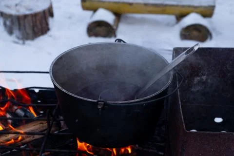 On a fire in a pot preparing mulled wine. Hot red wine on an open fire in win Stock Photos