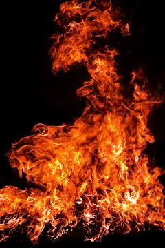 Fire produces rising flames. Fire forms blazing layer. Fire glows above bla.. Stock Photos