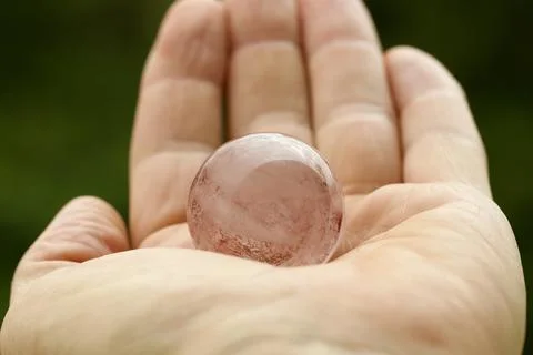 Fire Quartz Sphere in Human Hand. Stock Photos