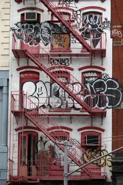 Fire Red Fire Escape and Graffiti on Tenement Building in New York Fotos de archivo