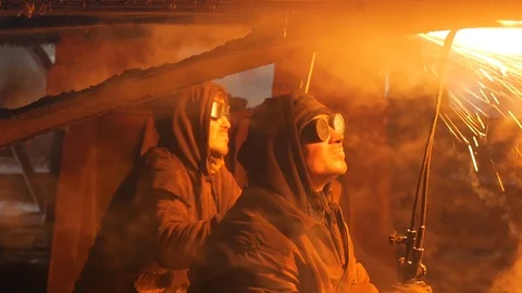 The fire is reflected in the glasses of two welders working at the dock Video stock 87505605