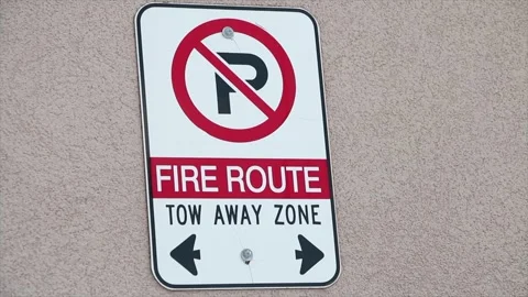 Fire route tow away zone vertical rectangle no parking sign on wall with arrows Stock Footage 249096682