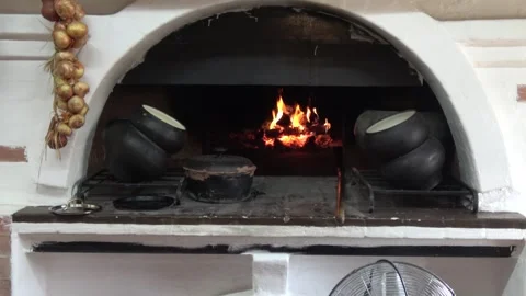 Fire in a Russian stove. In the foreground, close-up of cast iron pots Stock Footage 306361928