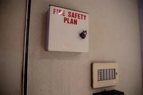 Fire safety plan box next to fire alarm monitor facing streets outside building. Stock Photos