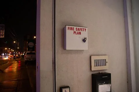Fire safety plan box next to fire alarm monitor facing streets outside building. Stockfoto's