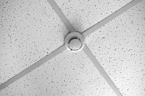 A fire sensor on the ceiling. Fire protection system in the form of a white b 写真素材