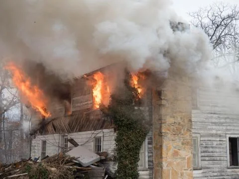 Fire shooting from windows during house fire Stock Photos