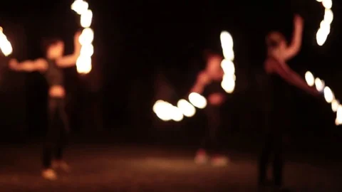 Fire show dancers spinning fire fans at night. Bokeh. Video stock 77233869