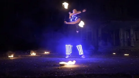 Fire show, dancing with flame, a man in a suit LED dances with fire, draws a Stock Footage 82289398