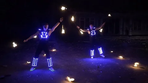 Fire show, dancing with flame, a man in a suit LED dances with fire, draws a Stock Footage 82290024