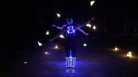 Fire show, dancing with flame, a man in a suit LED dances with fire, draws a Stock Footage 82291126