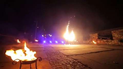 Fire show. fire burns in the foreground. Artists twist fire objects in their Stock Footage 84330578