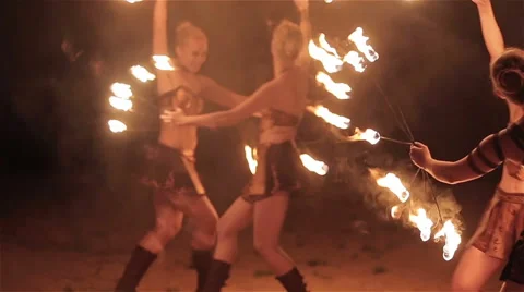 Fire show performance. Four girls female fire performers dance with fire fans Stock Footage 62496006