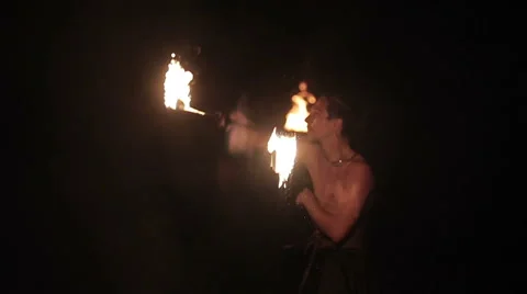 Fire show performance. Handsome male fire performer twirling fire baton ignited Stock Footage 62495883