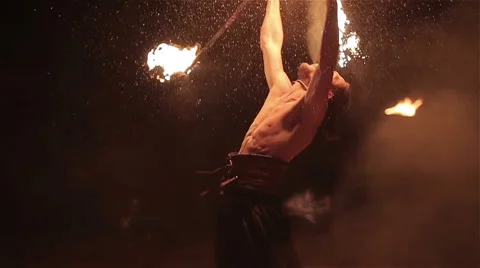 Fire show performance. Male fire performer twirles fire baton and fire breathing Video stock 62495826