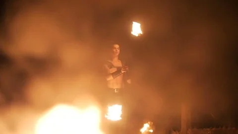 Fire show performance. Three handsome male fire performers dance twirling two Stock Footage 71532676