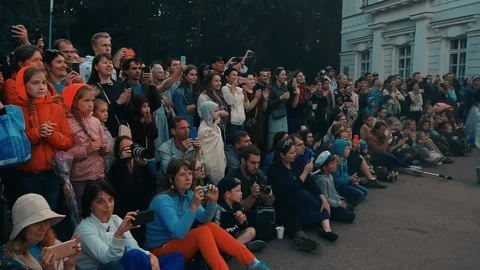 Fire show. Spectators stand and sit on the asphalt, film performance on phone, Stock Footage 160804402