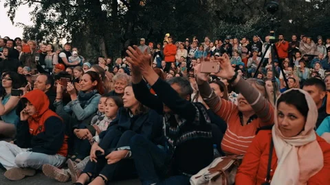 Fire show. Spectators stand and sit on the asphalt, film performance on phone, Stock Footage 160804506