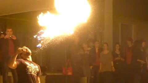 Fire show. Young man firebreathing, girl juggling with fire Stock Footage 62880385
