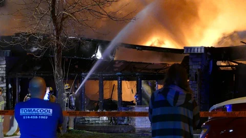 Fire showing thru two local bystanders who lost their bar to fire Stock Footage 129987484