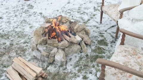 Fire on the snow in the winter forest with the comfortable armchairs. Stock Footage 146980669