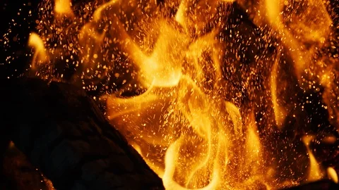 Fire sparks moving on dark at black background coming from brightly burning warm Vídeo Stock 89800043