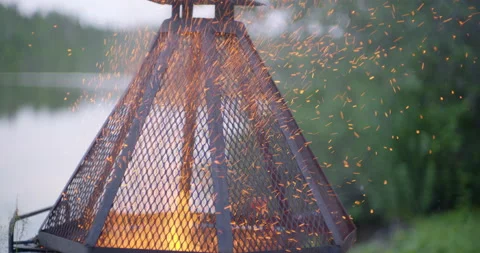 Fire sparks in slow motion at the campfire pit by the lake at evening Stock Footage 130927983