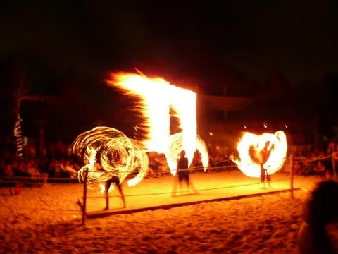 Fire Spinners on Beach at Night Stock Photos